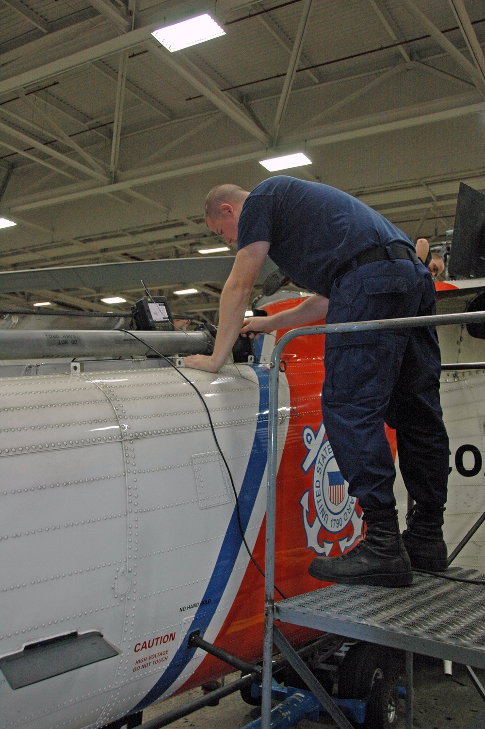 Coast Guard MH-60 Jayhawk helicopter aviation maintenance technician conducts non-destructive inspection testing in Sitka, Alaska