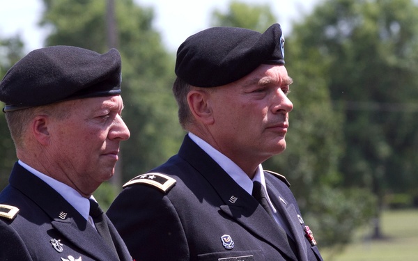 Two U.S. Army officers in dress uniforms stand at attention outdoors, likely during a formal military ceremony. The officer on the left is identified by his name tag as 'GOTHARD' and wears an Airborne tab, while the officer on the right is identified as 'BECK' and displays two-star major general rank insignia. Both wear black berets and Army Service Uniforms (ASU) with various medals and badges.