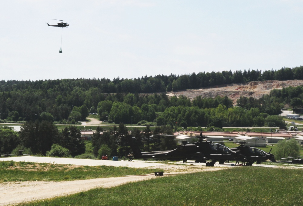Austrian helicopter flies over to Apaches doing sling-load