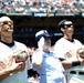 Petty Officer 3rd Class Christianne Hobelman renders a salute while standing between two San Francisco Giants players