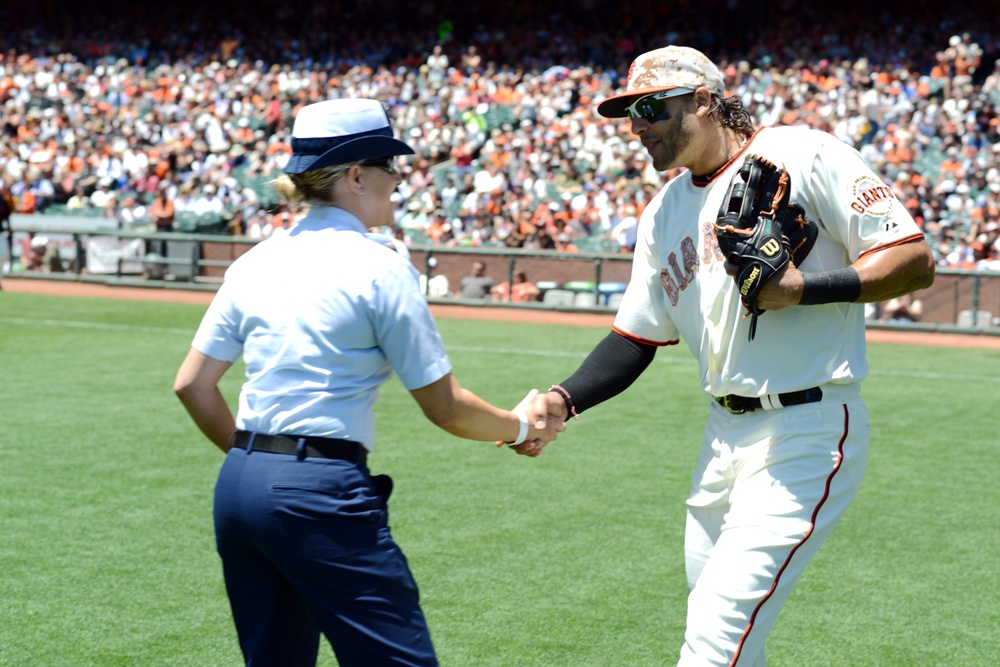 Petty Officer 1st Class Daniell Lashbrook greets San Francisco Giants player Michael Morse at his starting position on Memorial Day
