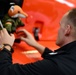 A NATO officer places his air crew's mascot on a Coast Guard helicopter