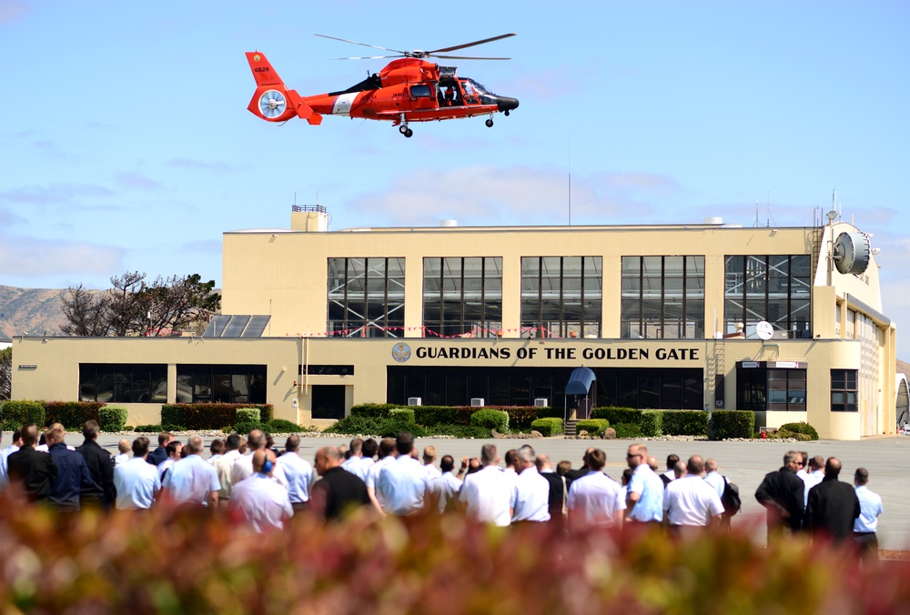 A group of NATO officers visiting Coast Guard Air Station San Francisco observe a helicopter demonstration