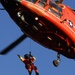Coast Guard MH-65 Dolphin helicopter crew conducts vertical surface training hoist operation in Kodiak, Alaska