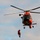 Coast Guard MH-65 Dolphin helicopter crew conducts vertical surface training hoist operation in Kodiak, Alaska
