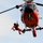 Coast Guard MH-65 Dolphin helicopter crew conducts vertical surface training hoist operation in Kodiak, Alaska