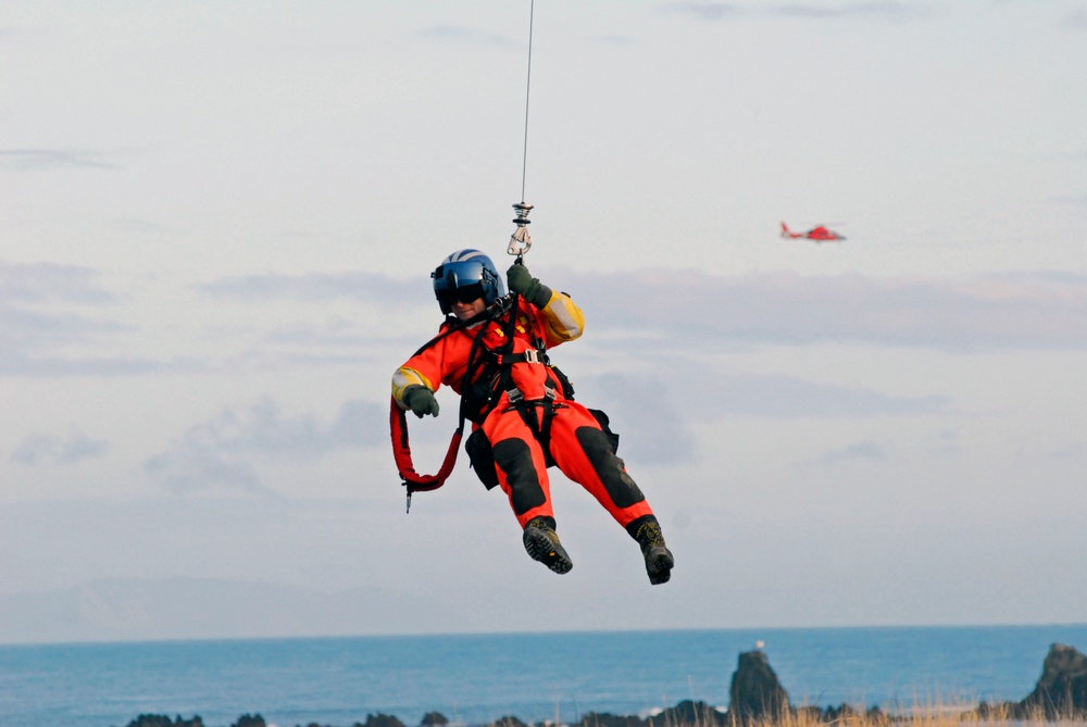 Coast Guard MH-65 Dolphin helicopter crew conducts vertical surface training hoist operation in Kodiak, Alaska