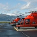 Coast Guard MH-65 Dolphin helicopters stand ready for deployment on the flight line in Kodiak, Alaska