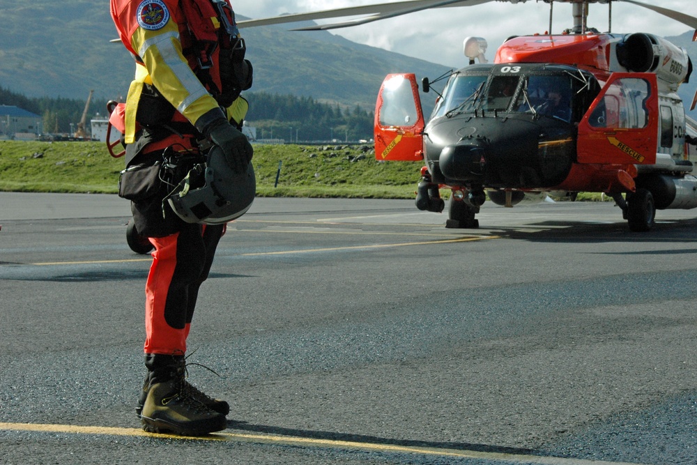 A Coast Guard aviation survival technician and MH-60 Jayhawk helicopter crew returns from a training flight in Kodiak, Alaska