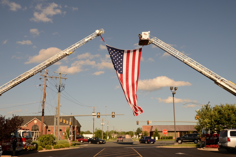 A US flag is draped between the ladder of Stafford Volunteer Fire Department’s Truck Company 2