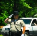 A Stafford County, Virginia, deputy sheriff temporarily closing a roadway, salutes the funeral procession