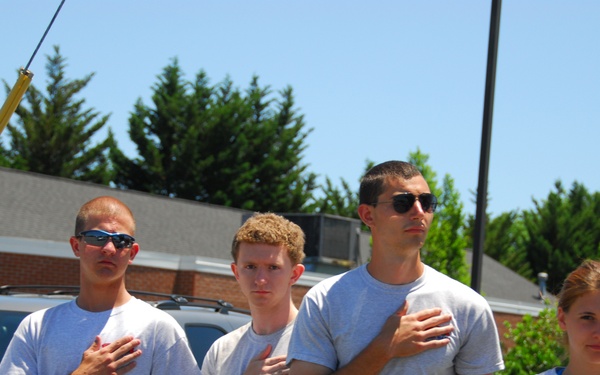 A group of teens salute the funeral procession