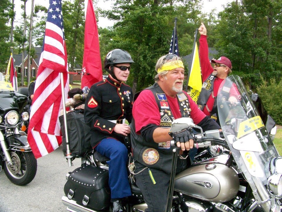 Lance Cpl. Kyle Carpenter riding on the back of a Harley-Davidson