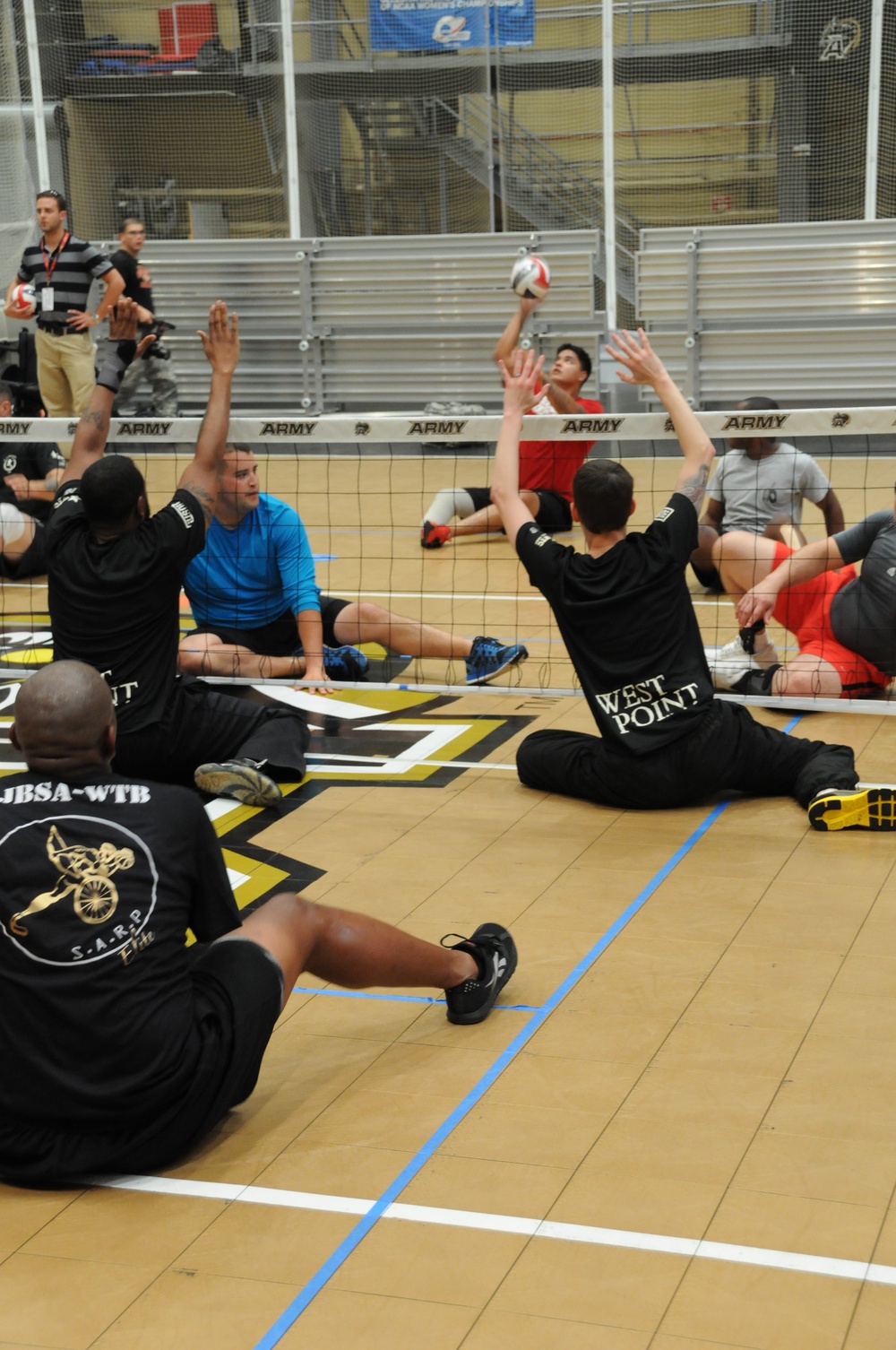 Marine Sgt. Alex Nguyen serves during sitting volleyball practice at the 2014 US Army Warrior Trials