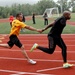 Two Army track team members smoothly pass the baton during practice at the 2014 Army Warrior Trials