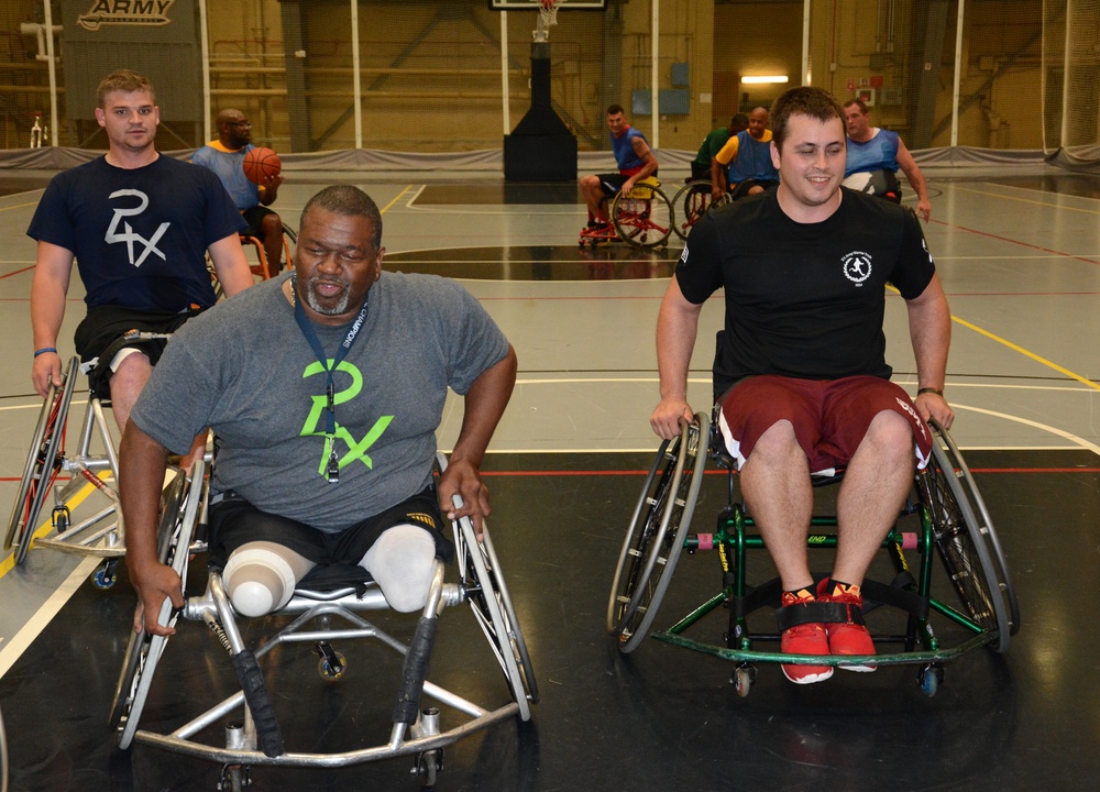 Wheelchair basketball coach shares tips to a player during training at the 2014 Warrior Trials