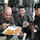 ROK soldiers, US Marines strap in for Mountain Warfare Training Course Three military personnel are sharing a meal together, with one soldier in USMC MARPAT digital camouflage eating from a Korean-style meal tray containing rice, curry, and kimchi. Two soldiers wearing Republic of Korea Army (ROKA) camouflage uniforms observe and interact with him, one smiling. The scene appears to depict a joint military exercise or training event between US and South Korean forces.