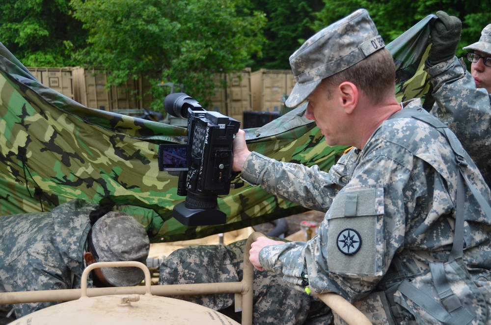 Staff Sgt. Michael O’Brien, public affairs sergeant from 354th Mobile Public Affairs Detachment takes video footage of soldiers from 418th Quartermaster Battalion taking fuel samples for testing