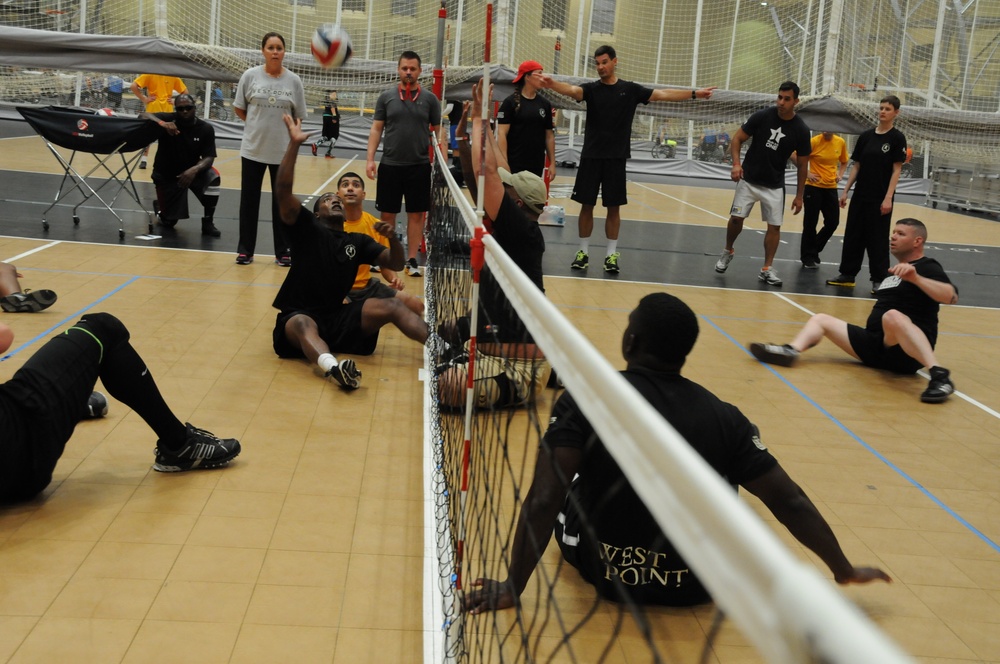 Spc. James Taylor sets a ball during sitting volleyball practice at the 2014 US Army Warrior Trials