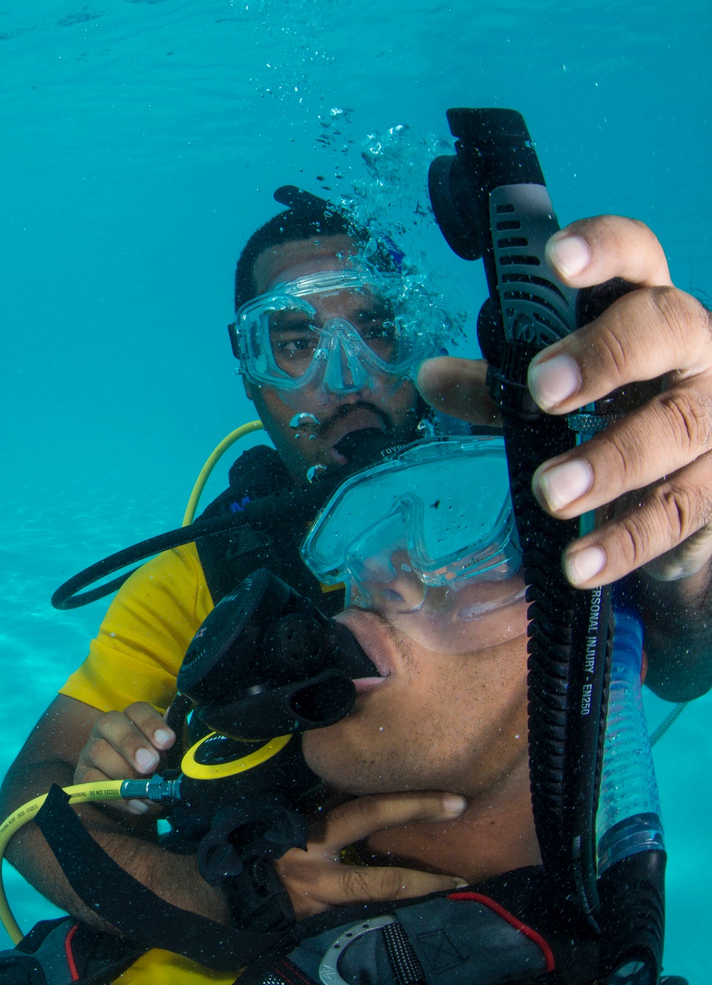 US Navy divers and Belizean Coast Guard divers practice SCUBA emergency procedures in a pool