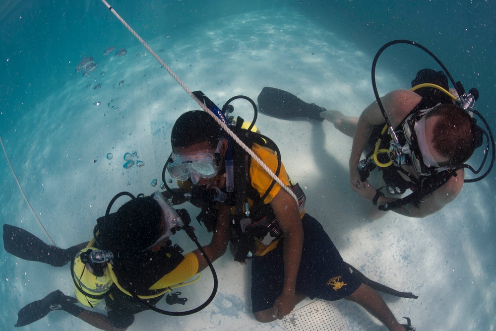 US Navy divers and Belizean Coast Guard divers practice SCUBA emergency procedures in a pool