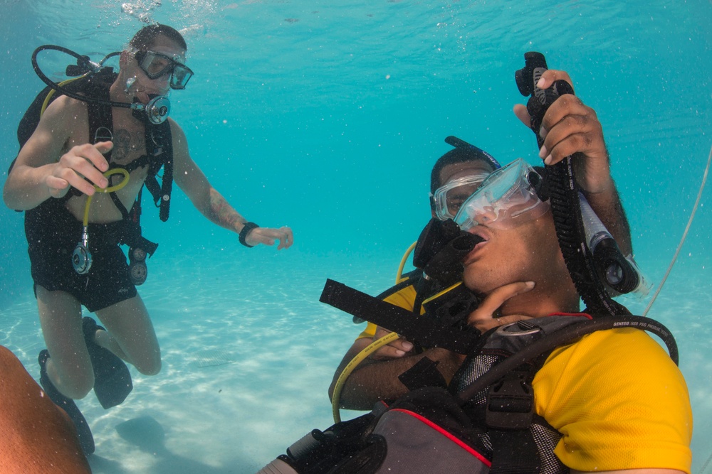 US Navy divers and Belizean Coast Guard divers practice SCUBA emergency procedures in a pool