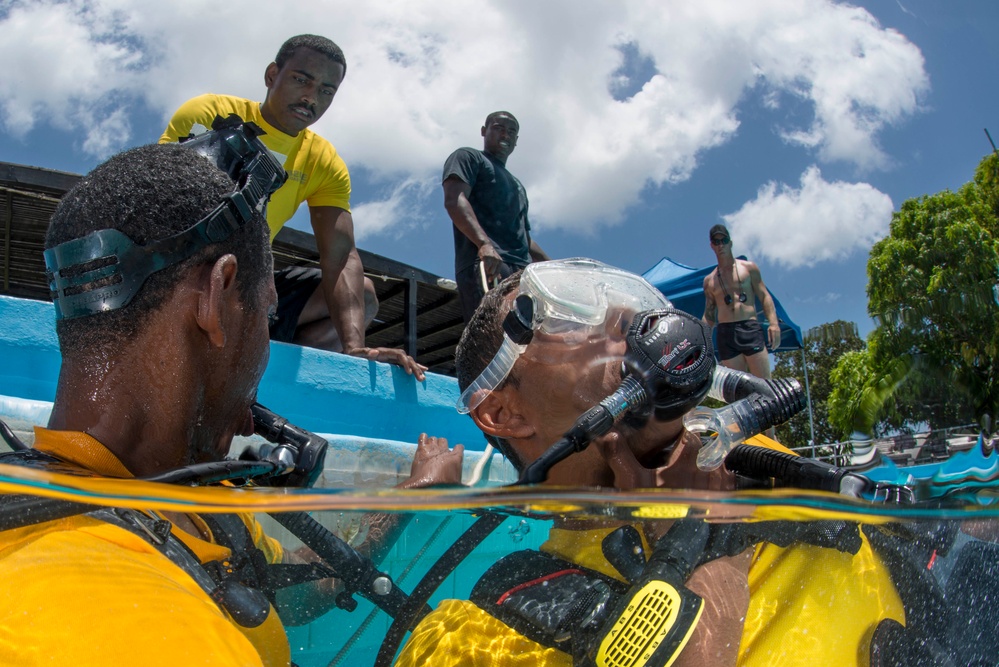 US Navy divers and Belizean coast guard divers practice SCUBA emergency procedures in a pool