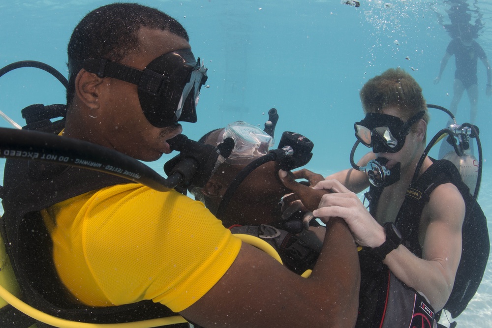 US Navy divers and Belizean coast guard divers practice SCUBA emergency procedures in a pool