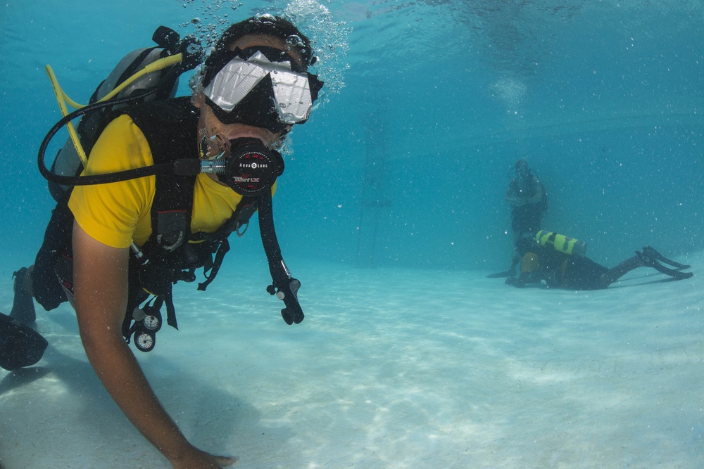 US Navy divers and Belizean coast guard divers practice SCUBA emergency procedures in a pool