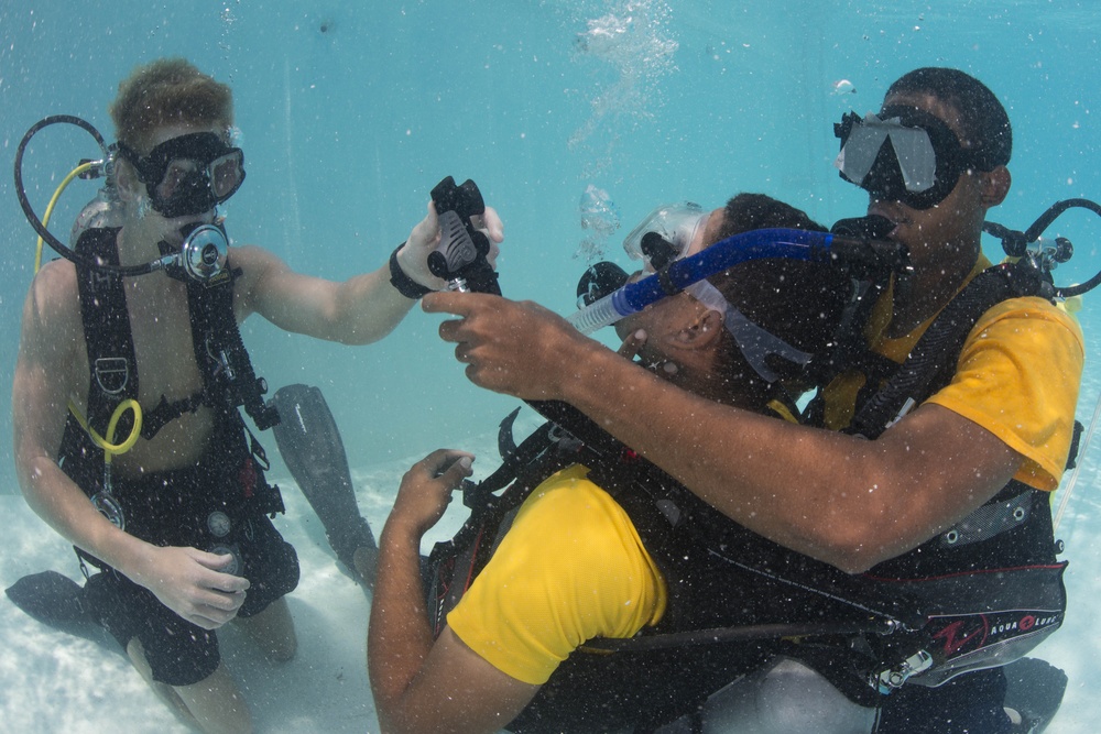 US Navy divers and Belizean coast guard divers practice SCUBA emergency procedures in a pool