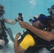 US Navy divers and Belizean coast guard divers practice SCUBA emergency procedures in a pool