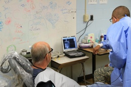 Patient sees own X-ray with hygienists during Southern Care 2014