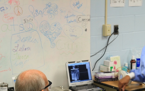 Patient sees own X-ray with hygienists during Southern Care 2014