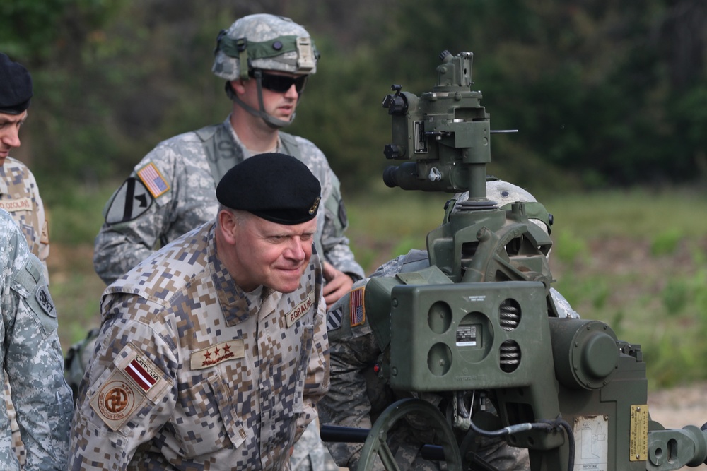 Lt. Gen. Raimonds Graube, Latvian Chief of Defense, observes the information display screen on an M777A1 howitzer of Alpha Battery, Ist Battalion, 119th Field Artillery Regiment