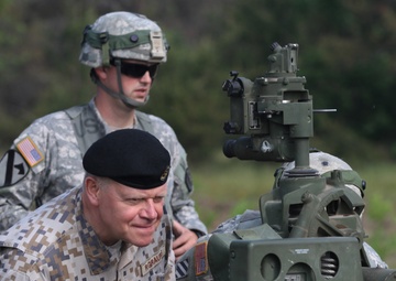 Lt. Gen. Raimonds Graube, Latvian Chief of Defense, observes the information display screen on an M777A1 howitzer of Alpha Battery, Ist Battalion, 119th Field Artillery Regiment