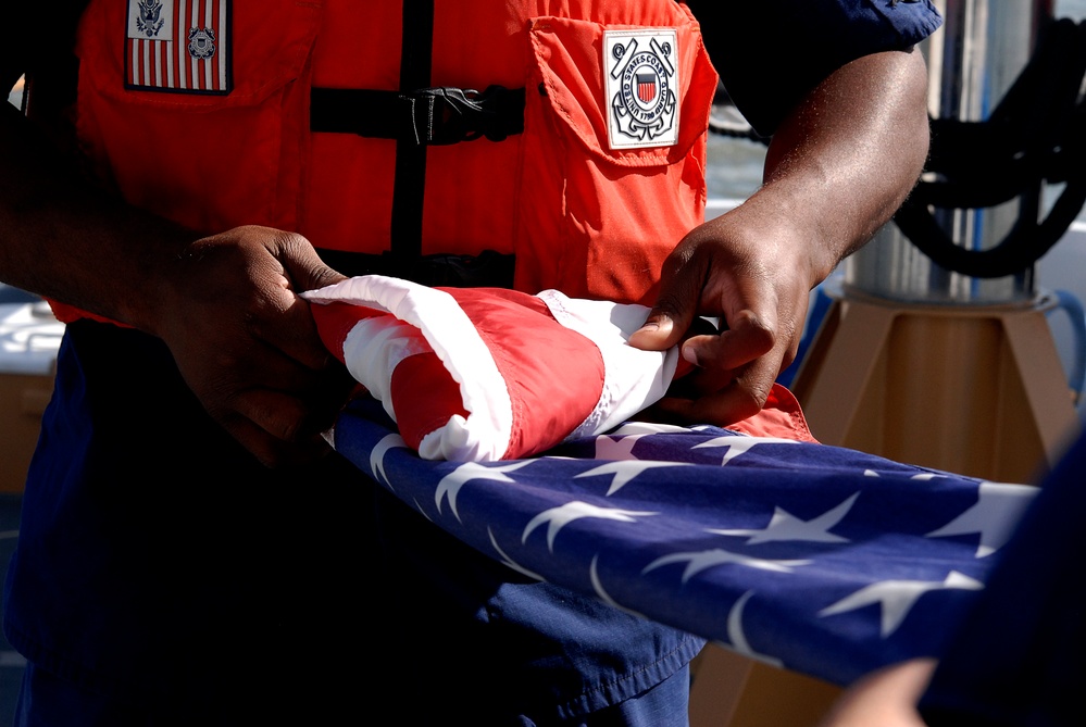 Coast Guard member folds National Ensign