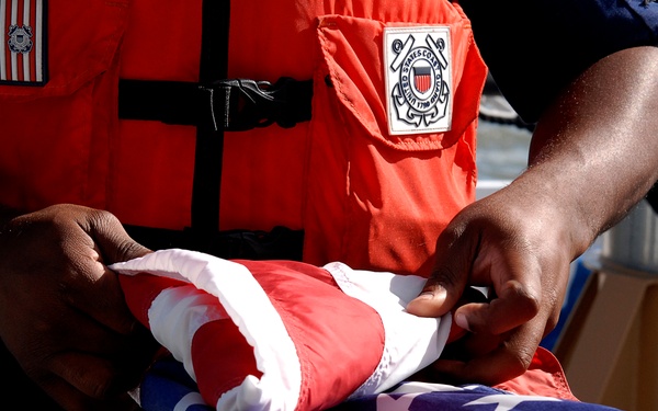 Coast Guard member folds National Ensign