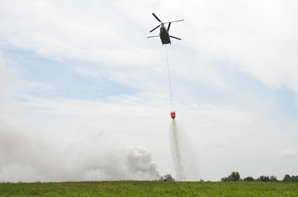 A CH-47 Chinook assigned to 2nd Battalion, 4th Aviation Regiment, 4th Combat Aviation Brigade, drops water on a simulated structure fire