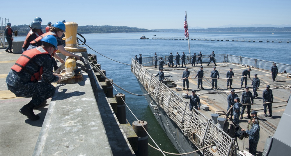 Sailors assigned to the aircraft carrier USS Nimitz (CVN 68) handle lines as the Arleigh Burke-class destroyer USS Howard (DDG 83) moors to the pier at Naval Station Everett