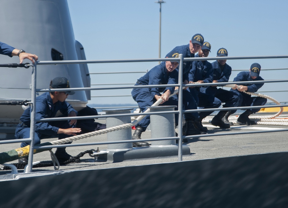 Sailors assigned to the Ticonderoga-class guided-missile destroyer USS Chancellorsville (CG 62) pull in a line as the ship moors to the pier at Naval Station Everett