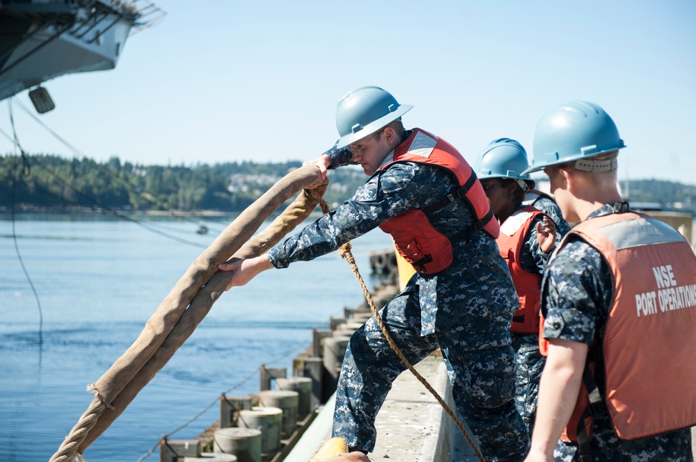 Sailors assigned to the aircraft carrier USS Nimitz (CVN 68) handle lines as the Wasp-class amphibious assault ship USS Essex (LHD 2) departs from Naval Station Everett (NSE) on her way to Seattle for the 65th annual Seattle Seafair Fleet Week