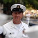 A U.S. Navy senior enlisted sailor in Service Dress White uniform is photographed outdoors at what appears to be a formal military event. His name tag reads 'TOM HOWARD' with the subtitle 'PACIFIC FLEET MASTER CHIEF,' indicating a very senior enlisted position. He wears multiple decorations, warfare badges, and the distinctive Master Chief Petty Officer cap device.