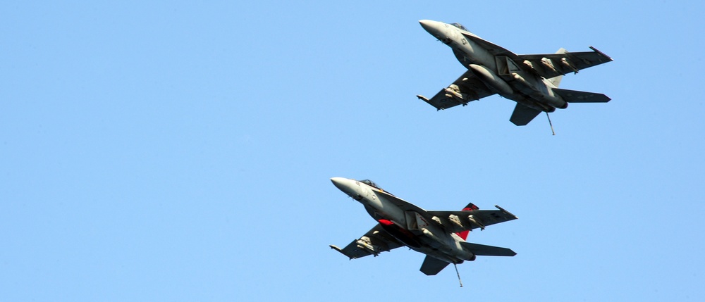 Super Hornets fly over USS George H.W. Bush