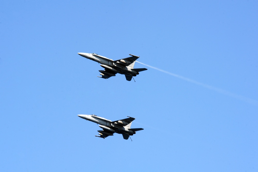 F/A-18C Hornets fly over USS George H.W. Bush