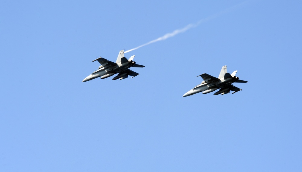 F/A-18C Hornets fly over USS George H.W. Bush