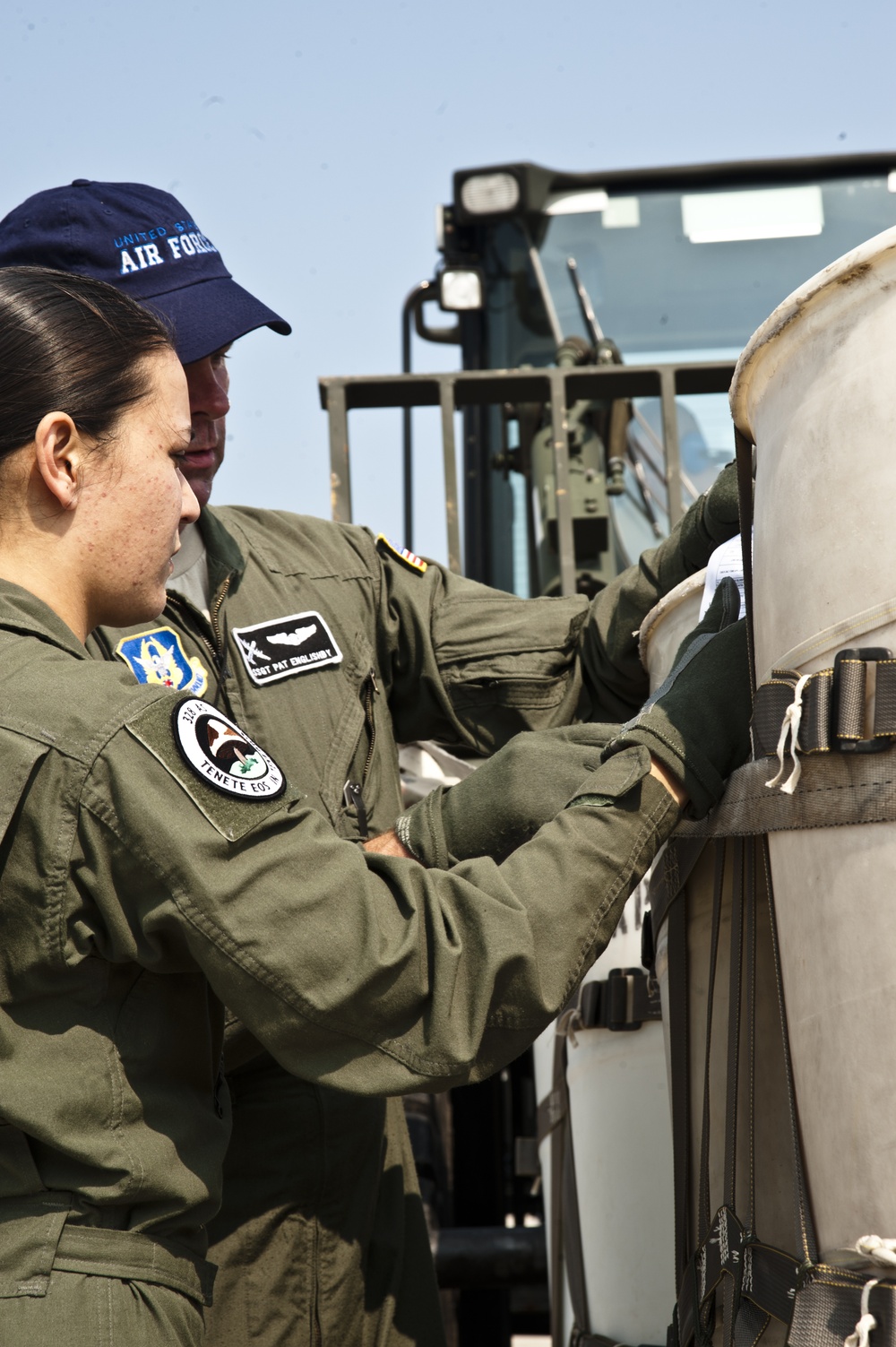 Staff Sgt. Pat Englishby and Senior Airman Rochelle Densmore inspect a payload in preparation of a heavy drop