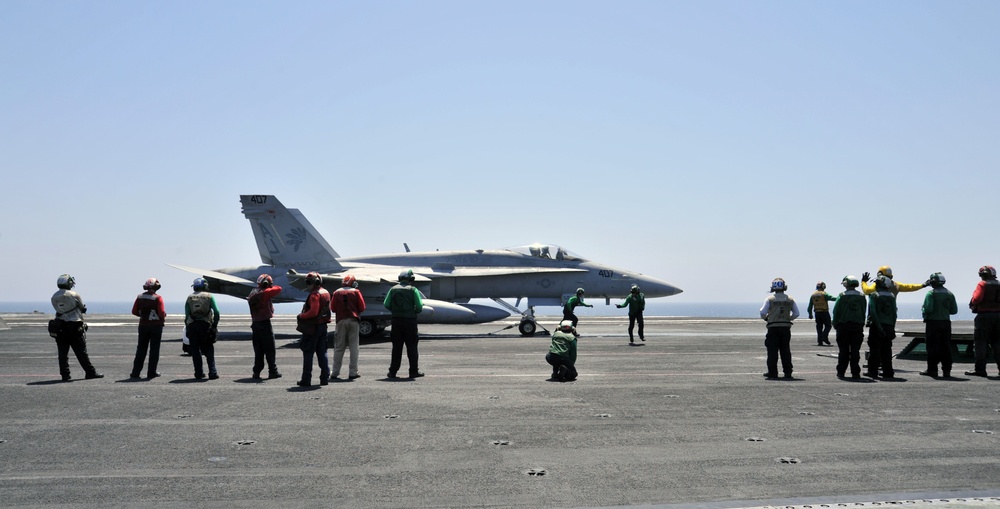 F/A-18C Hornets prepare for takeoff during operations aboard USS George H.W. Bush in the Arabian Gulf