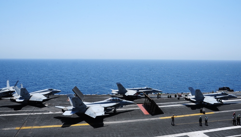 F/A-18C Hornets prepare for takeoff during operations aboard USS George H.W. Bush in the Arabian Gulf