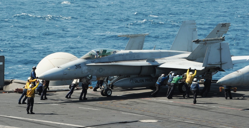 F/A-18C Hornets prepare for takeoff during operations aboard USS George H.W. Bush in the Arabian Gulf