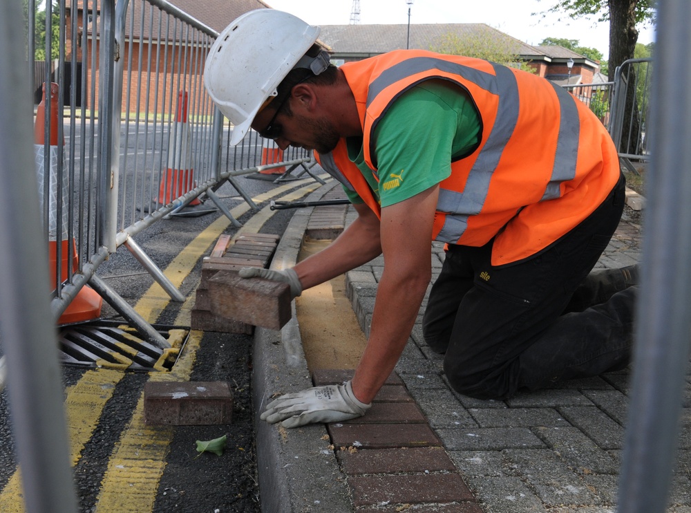 Contractors level sidewalk, ensures safety for pedestrians